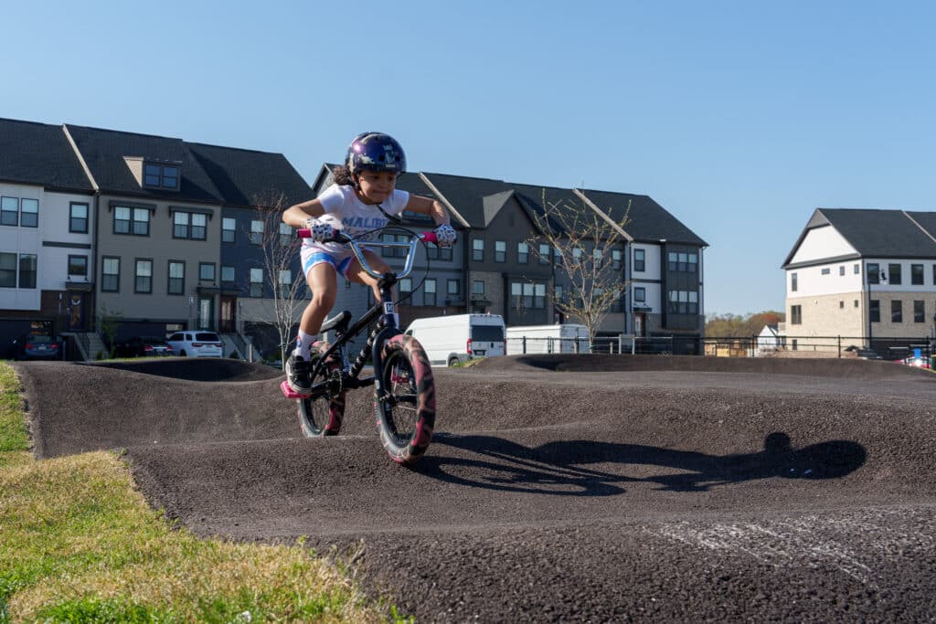 Young girl riding on the beginner pump track