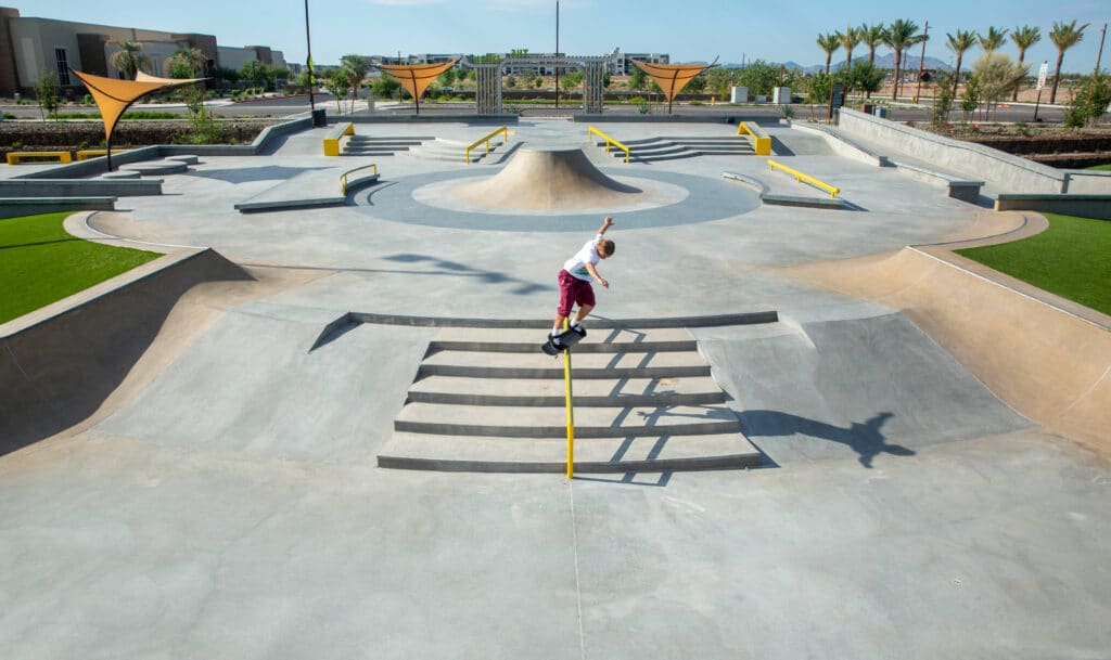 Skateboarder in a skatepark grinding a stair rail