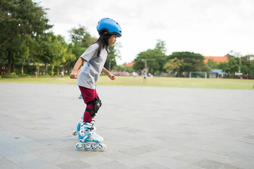 Young girl roller skating on flat path