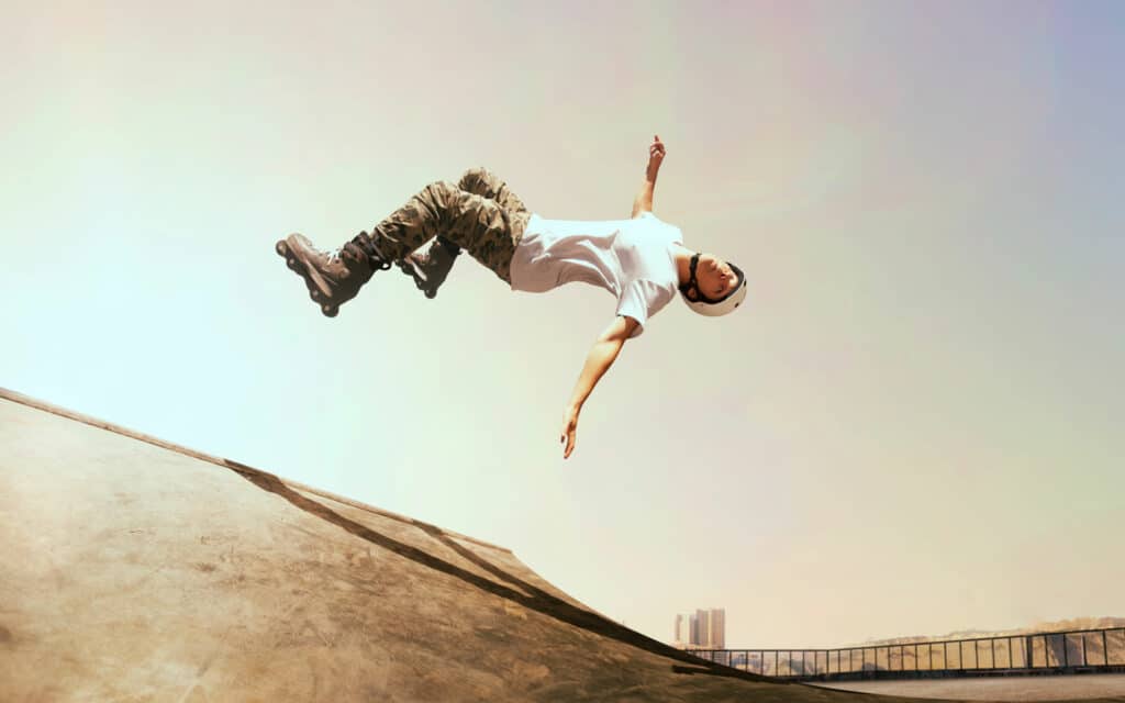 Roller skater doing a backflip off of a vert ramp