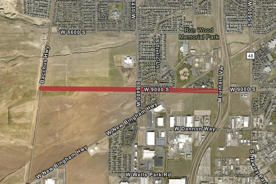 Aerial map view showing a red line running horizontally across W 9000 S street with surrounding areas labeled, including Bacchus Hwy, Ron Wood Memorial Park, and W New Bingham Hwy. Residential and industrial areas are visible.