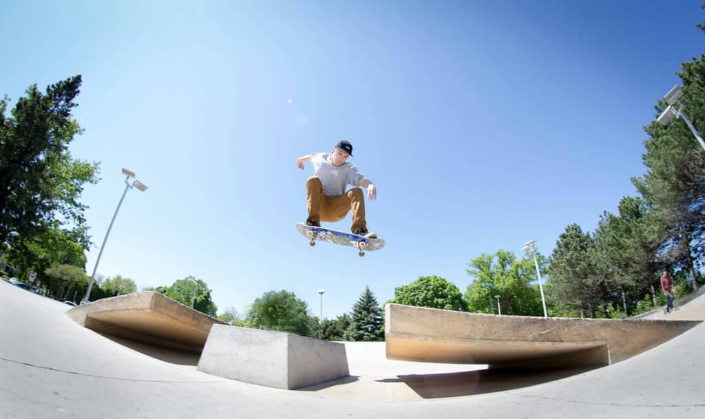 Skateboarder flys over a medium sized gap between two ramps