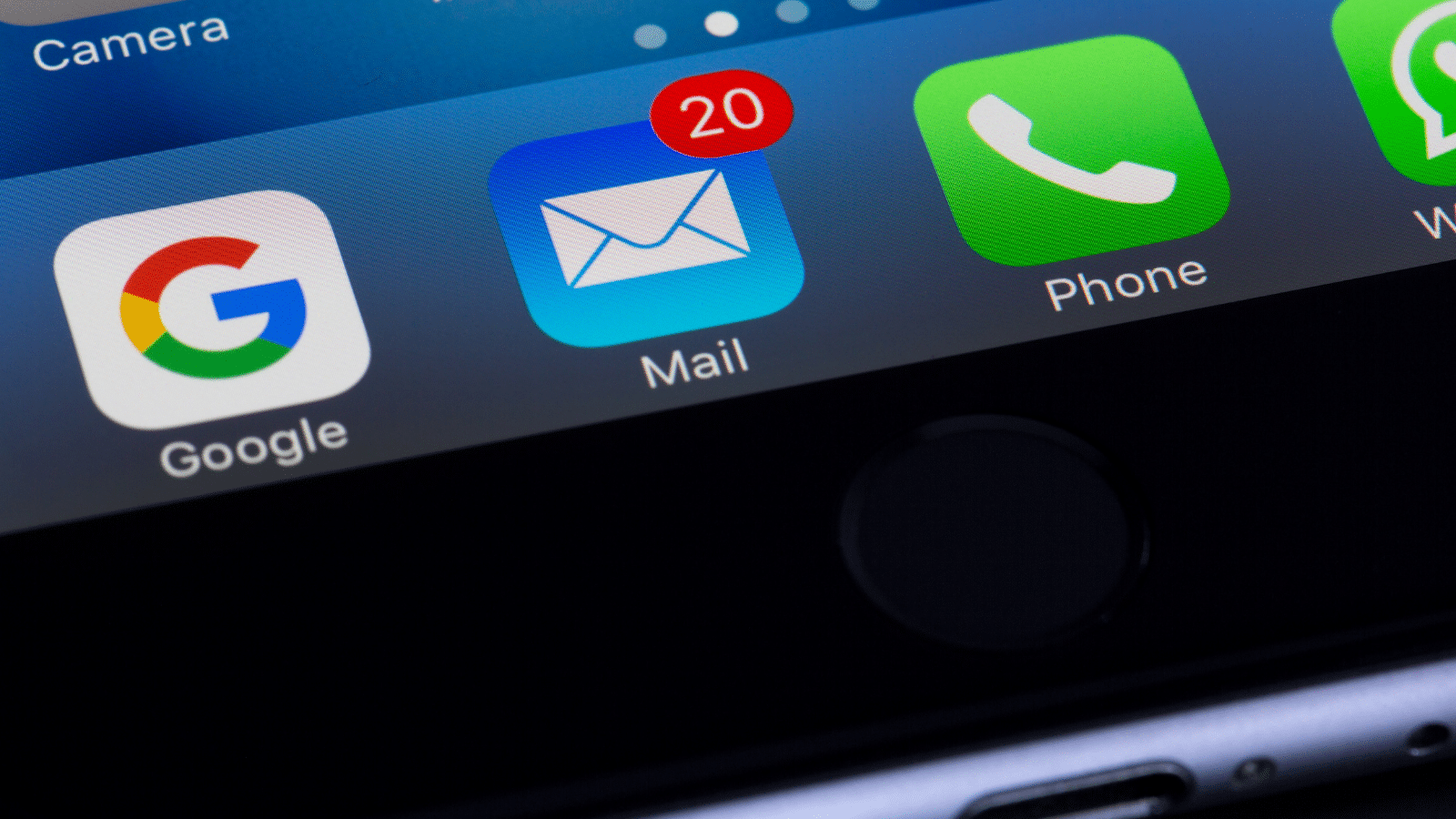 Close-up of a smartphone screen showing app icons. The Mail app displays a red notification badge with the number 20, indicating unread messages. Other visible apps include Google and Phone, set against a black background.